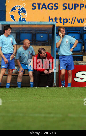 Fußball - Coca-Cola Football League Two - Mansfield Town / Lincoln City - Field Mill. Lincoln City Manager John Schofield telefoniert während des Spiels schnell Stockfoto