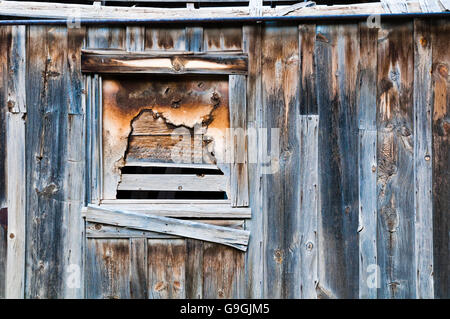 Fenster auf eine alte Holzhütte mit Brettern. Stockfoto