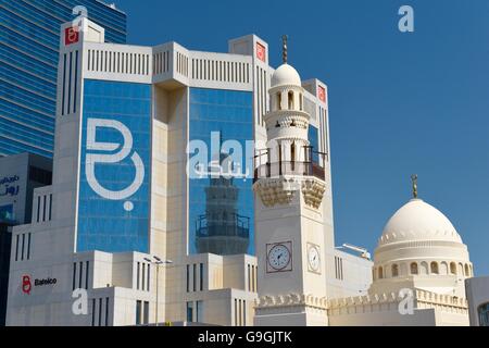 Das einzigartige Uhrturm Minarett in die neue Al Yateem Mosque in Manama, Bahrain steht vor den Ämtern Batelco Telekom Stockfoto