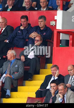 Manchester United Manager Sir Alex Ferguson (rechts unten) Ruft als ehemaliger Assistent am Telefon an Brian Kidd schaut von der Tribüne Stockfoto