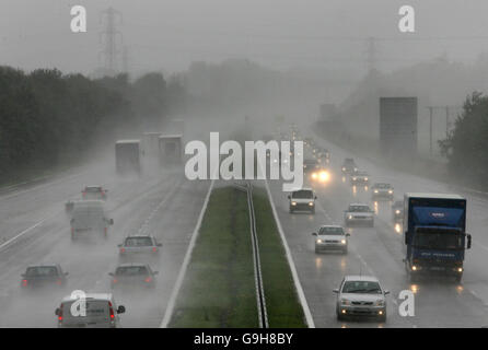 Sintflutartige Regenfälle führen auf der M5 in der Nähe von Cullompton in Devon zu schlechter Sicht und zu langsamem Verkehr. Stockfoto