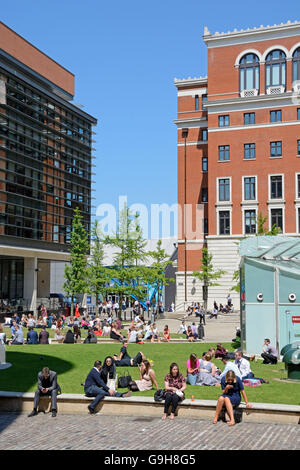 Menschen entspannen in der Sommersonne am Zentralplatz in Brindleyplace, Birmingham, England, Vereinigtes Königreich, West-Europa. Stockfoto