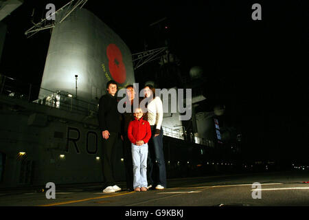 Elizabeth Chapman steht mit ihren Töchtern Chloe, 16 Georgina, 8, und ihrem Sohn Ben, 13, auf dem Flugdeck der HMS Illustrious, als der Flugzeugträger in Greenwich, London, anlegt. Stockfoto