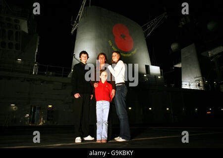 Elizabeth Chapman steht mit ihren Töchtern Chloe, 16, Georgina, 8 und ihrem Sohn Ben, 13, auf dem Flugdeck der HMS Illustrious, als der Flugzeugträger in Greenwich, London anlegt. Stockfoto