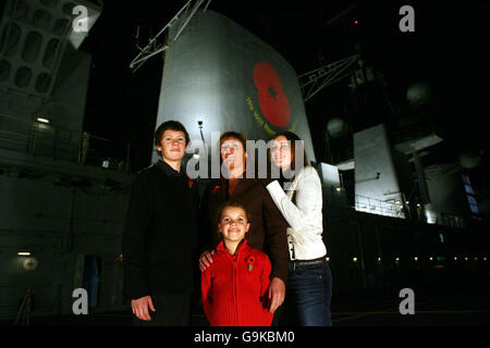 Elizabeth Chapman steht mit ihren Töchtern Chloe, 16, Georgina, 8 und ihrem Sohn Ben, 13, auf dem Flugdeck der HMS Illustrious, als der Flugzeugträger in Greenwich, London anlegt. Stockfoto