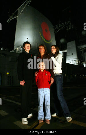 Elizabeth Chapman steht mit ihren Töchtern Chloe, 16, Georgina, 8 und ihrem Sohn Ben, 13, auf dem Flugdeck der HMS Illustrious, als der Flugzeugträger in Greenwich, London anlegt. Stockfoto