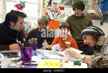 Die Popband McFly (von links nach rechts) Harry Judd, Dougie Poynter, Tom Fletcher und Danny Jones helfen Fergus Hunt, 11 Jahre alt, aus Chelmesford Essex, eine Weihnachtskarte im Great Ormond Street Children's Hospital im Zentrum von London zu entwerfen. Stockfoto