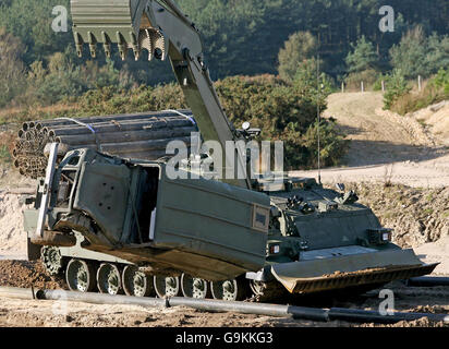 Der neue, schwer gepanzerte Ingenieur-Panzer Trojan der Armee bewegt Hindernisse wie Autos und Betonblöcke im Militärtrainingsgebiet Bovington in Dorset. Stockfoto