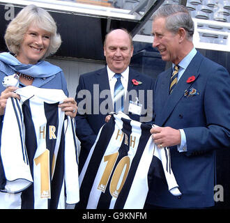 Der Prinz von Wales und die Herzogin von Cornwall werden während eines Besuchs im St James' Park von Clubvorsitzendem Freddy Shepherd (Mitte) mit Newcastle United Trikots überreicht. Stockfoto