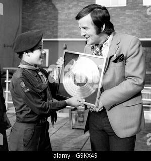 Disc-Jockey Alan 'Fluff' Freeman (r) präsentiert eine Goldscheibe an den 13-jährigen Paul Newman (l), einen Pfadfinder der 25. Coventry Scout Group, der die CD für den Verkauf von mehr Kopien des CBS 'Golden Hits'-Albums als jede andere Gruppe im Land erhielt. Stockfoto