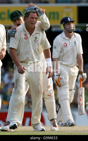 Der australische Shane Warne feiert mit Adam Gilchrist (links), nachdem er am vierten Tag des ersten Testmatches in Gabba, Brisbane, Australien, das Wicket des englischen Kapitäns Andrew Flintoff eingenommen hat. Stockfoto