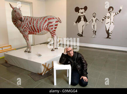 Der britische Künstler Damien Hirst sitzt einige Werke aus seiner persönlichen Sammlung zeitgenössischer Kunst, der "murderme", die er ab morgen in der Londoner Serpentine Gallery ausstellt. Stockfoto