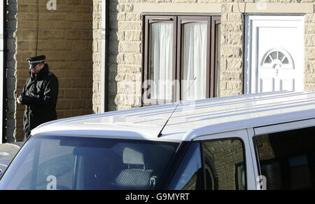 Ein Polizeibeamter steht vor einem Haus in Halifax, West Yorkshire, das heute nach morgendlichen Anti-Terror-Razzien durchsucht wurde. Stockfoto