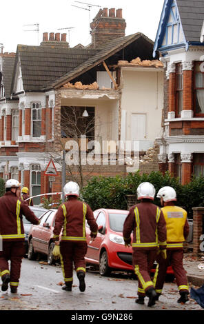 Eine Gruppe von Feuerwehrleuten geht in Richtung eines beschädigten Hauses in der Chamberlayne Road im Nordwesten Londons, nachdem ein Tornado durch den Vorort von Kensal Rise gerissen wurde. Stockfoto