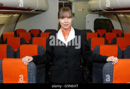 Emma Casey posiert in ihrer neuen easyJet-Uniform in einem Flugzeug am Kleiderbügel der Low-Cost-Fluggesellschaft am Flughafen Luton. Stockfoto