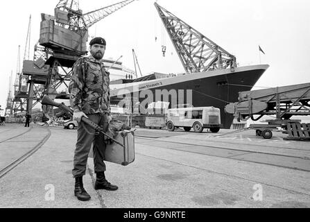 Ein Soldat steht mit seiner Spiegelreflexkamera und seinem Koffer am Kai von Southampton vor der QE2, bereit zum Krieg. Er gehörte zu einem Kontingent von 3,000 Truppen, die das Liner einschifften, um nach den Falklands zu segeln. Stockfoto