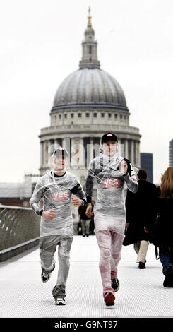 Beim Start der EarthFireIce-Kampagne zur globalen Erwärmung laufen die Marathonläufer Ed Stumpf (links) und Sean Cornwell (rechts) zur Vorbereitung auf den Sahara-Marathon über die Millennium Bridge. Stockfoto