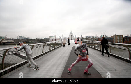 Beim Start der EarthFireIce-Kampagne zur globalen Erwärmung wärmen sich die Marathonläufer Ed Stumpf (links) und Sean Cornwell (rechts) auf der Millennium Bridge auf, um sich auf den Sahara-Marathon vorzubereiten. Sie planen, den Marathon in einem clingfilm zu laufen, um zu zeigen, wie die Welt durch CO2-Emissionen erstickt wird. Stockfoto