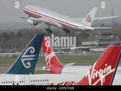 Generische Transport-PICs. Eine Boeing 777 von American Airlines fährt beim Start vom Londoner Flughafen Heathrow an zwei Virgin-Flugzeugen vorbei. Stockfoto