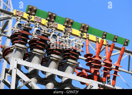 Isolatoren eines Kraftwerks mit großen elektrischen Hochspannungsleitungen verbunden um die Spannung Trafostecker Stockfoto