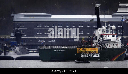 Das Greenpeace-Schiff Arctic Sunrise liegt neben dem Atom-U-Boot HMS Vigilant, das am Marinestützpunkt Faslane in Schottland angedockt ist. Stockfoto