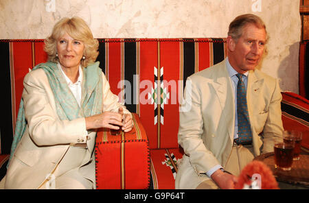 Der Prinz von Wales (rechts) und die Herzogin von Cornwall (links) sitzen, um Tee zu trinken, nachdem sie durch die Straßen eines traditionellen Marktes in Doha, Katar, gegangen sind. Stockfoto