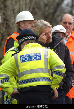 Virgin Boss Sir Richard Branson (Mitte) schaut auf die Überreste des Zuges, der in der Nähe von Little Docker Cottage in der Gegend von Greyrigg, in der Nähe von Kendal, Cumbria, abgestürzt ist. Stockfoto