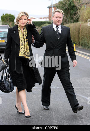 Der Tänzer Michael Flatley und seine Frau Niamh O'Brien kommen zur Beerdigung des Veranstalters Jim Aiken in der St. Brigid's Church, Belfast. Stockfoto