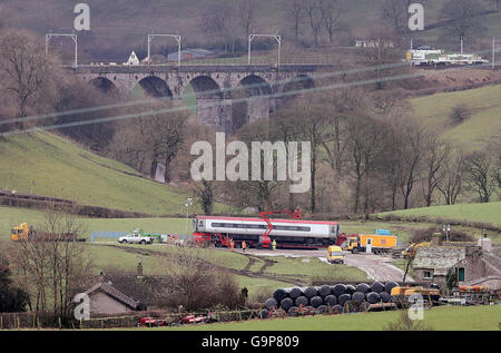 Die Szene des Eisenbahnunglücks Virgin in der Nähe von Greyrigg, Cumbria, wo die sorgfältige Operation zur vollständigen Wiedereröffnung der Westküstenlinie heute fortgesetzt wird, während Ingenieure die neun Wagen abbauen. Stockfoto