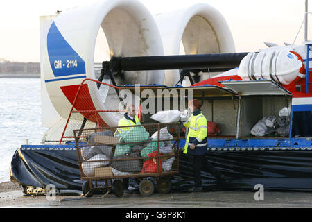 Die Mitarbeiter entfernen die Post von einem der beiden Hovertravel Hovertravel Hovertravel Luftkissenfahrzeuge, die den Solent zwischen Southsea in Portsmouth und Ryde auf der Isle of Wight durchqueren. Die zehnminütige Fahrt ist die schnellste Route über das Wasser für Pendler und Urlauber. Stockfoto