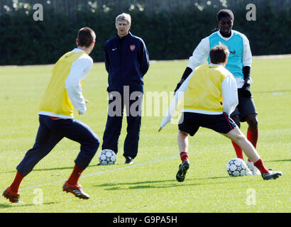 Emmanuel Adebayor (rechts) von Arsenal in Aktion, während Manager Arsene Wenger während einer Trainingseinheit in London Colney, London, aufschaut. Stockfoto