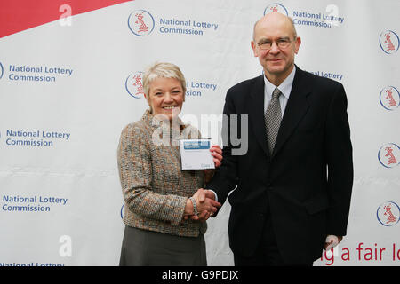 Die Vorstandsvorsitzende von Camelot, Dianne Thompson (links), übergibt Camelots Angebot für eine dritte Lizenzlaufzeit zur Leitung der UK National Lottery an Robert Foster, den Vorsitzenden des Project Board der National Lottery Commission (rechts), vor der National Gallery im Zentrum von London. Stockfoto