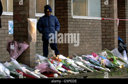 Ein kleiner Junge passiert Blumen, die in der Nähe der Wohnung im Fenwick Place, North Clapham, platziert wurden, wo der 15-jährige Billy Cox am Mittwoch tot aufgefunden wurde. Stockfoto