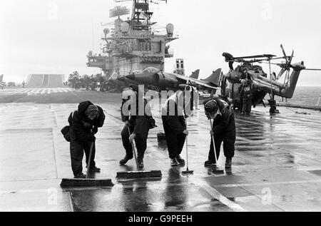 Diese Männer schrubben das 700 Meter lange Flugdeck der HMS Hermes. Stockfoto
