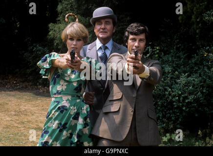 (L-R) Joanna Lumley, die Purdey spielt, Patrick Macnee, der John Steed spielt, und Gareth Hunt, der Mike Gambit spielt, aufgenommen während der Dreharbeiten in den Pinewood Studios Stockfoto