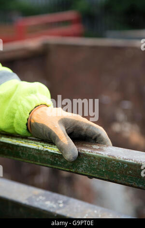 Ein Arbeiter tragen von Schutzhandschuhen und ein Hallo Vis Sicherheitsweste (Hallo Sichtbarkeit Jacke) Stockfoto