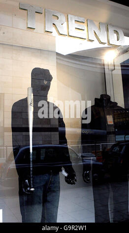 Bekleidungsgeschäft verteidigt bewaffneten Hoodie Schaufenster Stockfoto