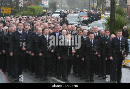 Die Feuerwehrleute marschieren vor dem Leichenschauhaus des freiwilligen Feuerwehrleuten Mike Liston, der zur Messe in der St. Senan's Church, Foynes, Irland, aufmarschiert. Stockfoto