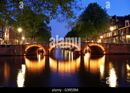 Beleuchtete Kanalbrücke in der Nacht auf den Kanal zwischen Prinsengracht und Brouwersgracht in Amsterdam, Holland Stockfoto