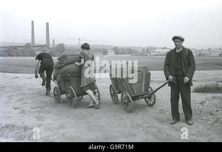 1930er Jahre, historisch, Transport von Säcke Kohle auf kleine Hand gezogen aus Holz zweirädrigen Karren, in der Nähe von Teplitz im Sudetenland, in der Pre-WW11 Tschechoslowakei Stockfoto