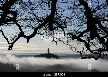 Das Wallace Monument in der Nähe von Stirling, Schottland, steht über dem frühen Morgennebel. Stockfoto