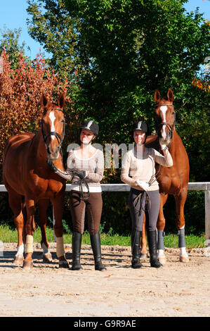 Zwillinge mit Pferden, deutschen Warmblut, Sorrell, Trense, Reithelm Stockfoto