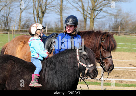 Mutter und Tochter mit Ponys, isländischen Pony, Shetland Pony Stockfoto