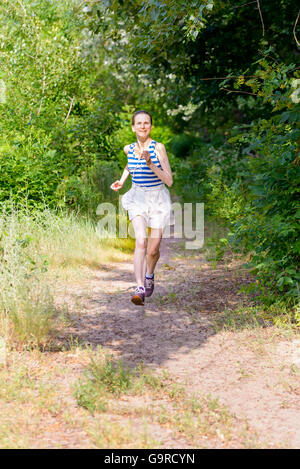 Eine glückliche senior Frau läuft im Wald an einem warmen Sommertag Stockfoto