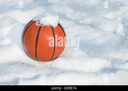 Basketball auf einem Spielplatz mit Schnee bedeckt Stockfoto