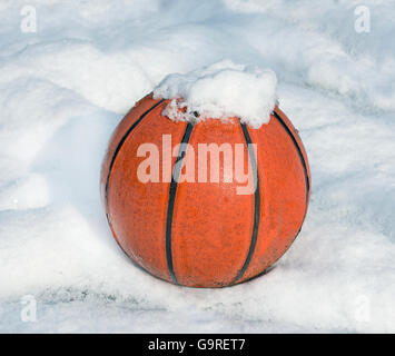 Basketball auf einem Spielplatz mit Schnee bedeckt Stockfoto