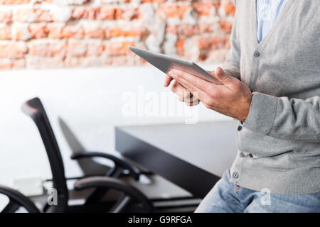 Person mit Tablet sitzen Büro Schreibtisch Geschäftsmann Stockfoto