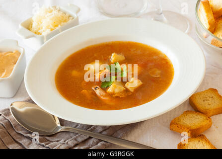 Ein Teller mit französischen Fisch und Meeresfrüchte Suppe, serviert mit Toast, Rouille-Sauce und geriebenem Käse Stockfoto