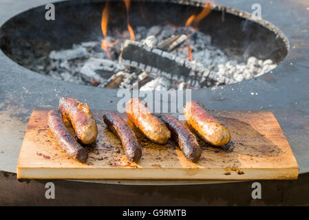 Würstchen auf Cutting Board und Barbecue grill Stockfoto