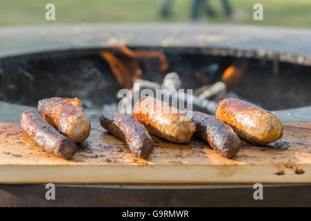 Würstchen auf Cutting Board und Barbecue grill Stockfoto